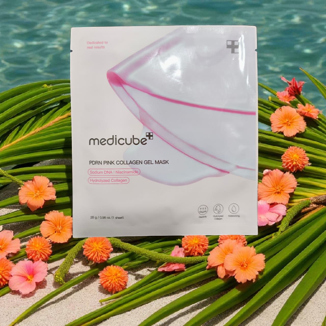  medicube pink collagen gel mask packaging with flowers and green leaves on a beach background