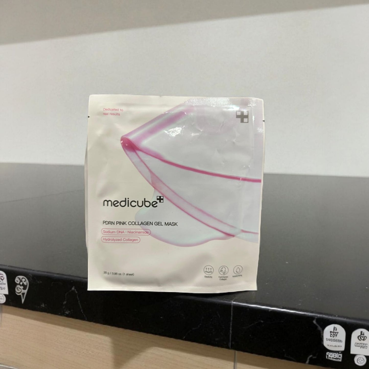 Medicube pink collagen gel mask package on a black countertop